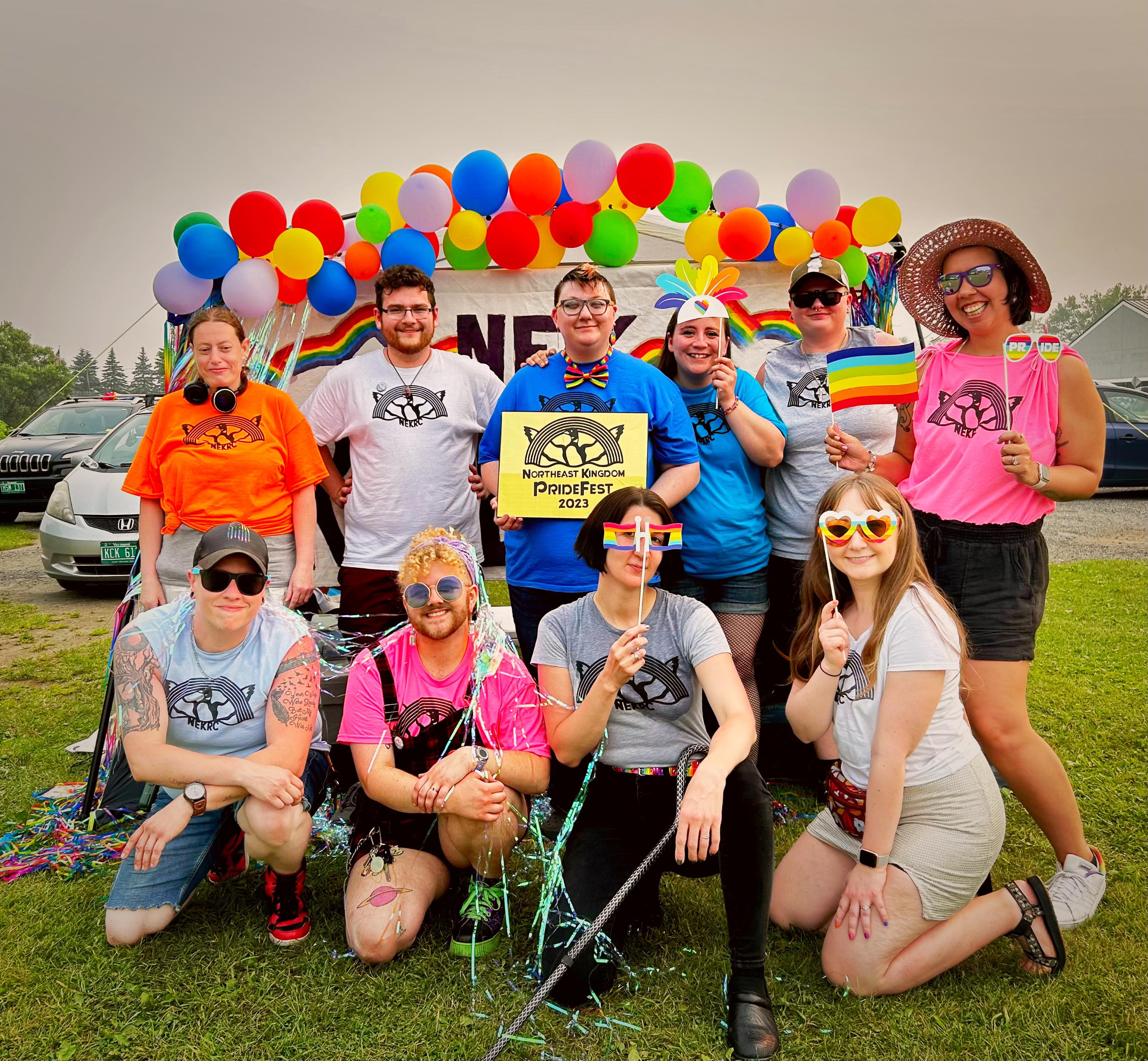 Volunteers in front of rainbow balloons